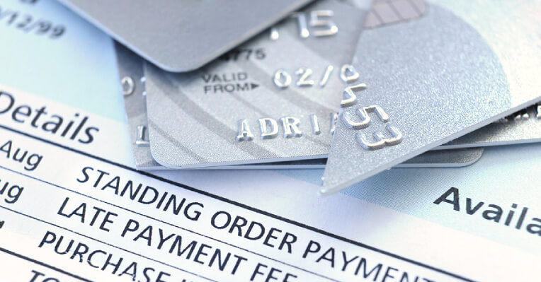 Pieces of cut credit cards lying on late payment notices