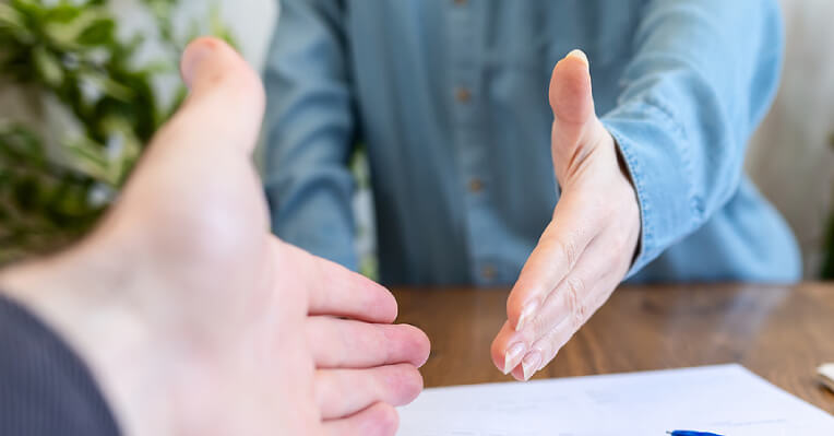 Close-up of hands of a man and woman about meet in a handshake