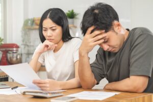 A young asian couple feeling stressed after borrowing from a loan shark and getting harrassed